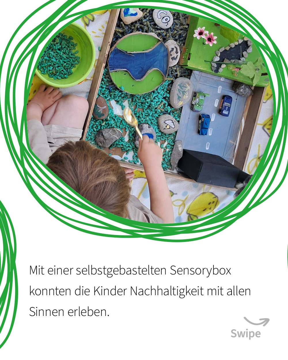 Folie 5: Kind spielt in einer selbstgebastelten Sensory-Box mit grünen Kieseln, einer kleinen Spielzeugstraße und Steinen zum Sinneslernen. (c) KibeV