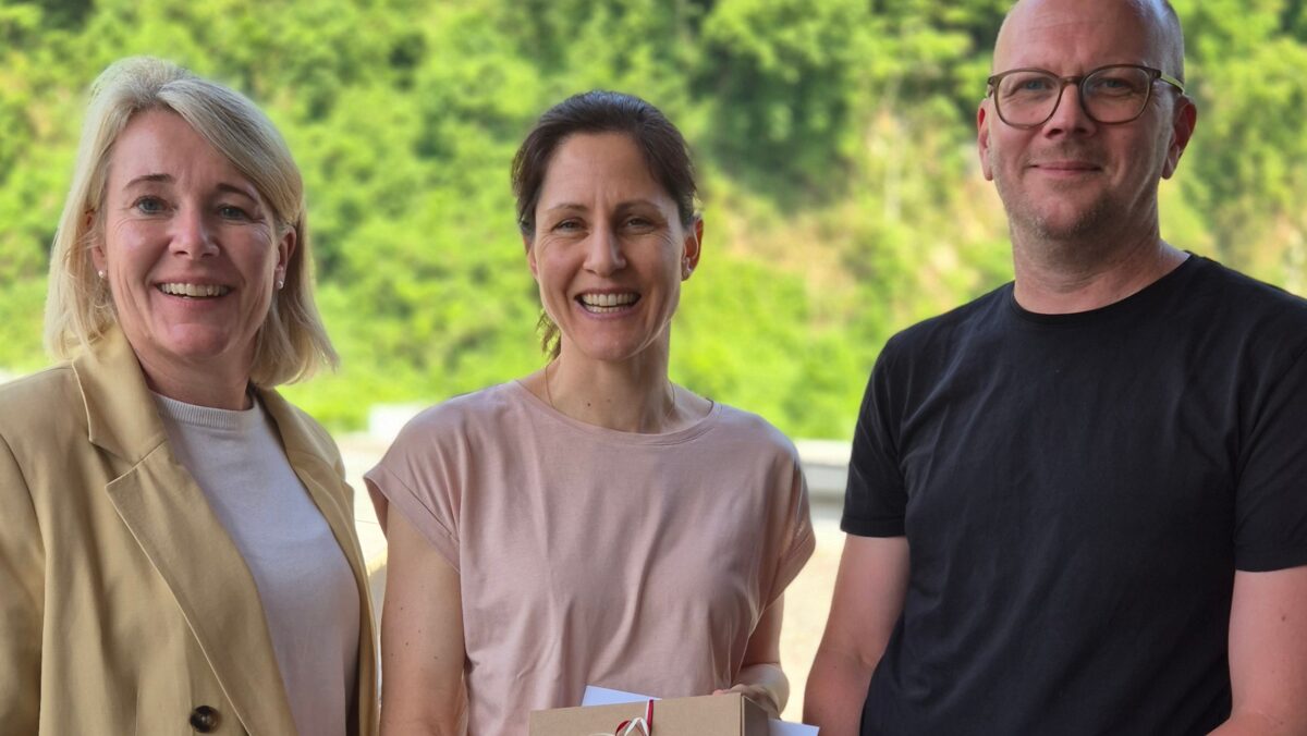 Betriebsärztin Veronika Tschann (Mitte) und unsere Geschäftsführung (Yvonne Antretter-Wiedl, li, und Patrick Malang, re) lächeln in die Kamera. (c) KibeV