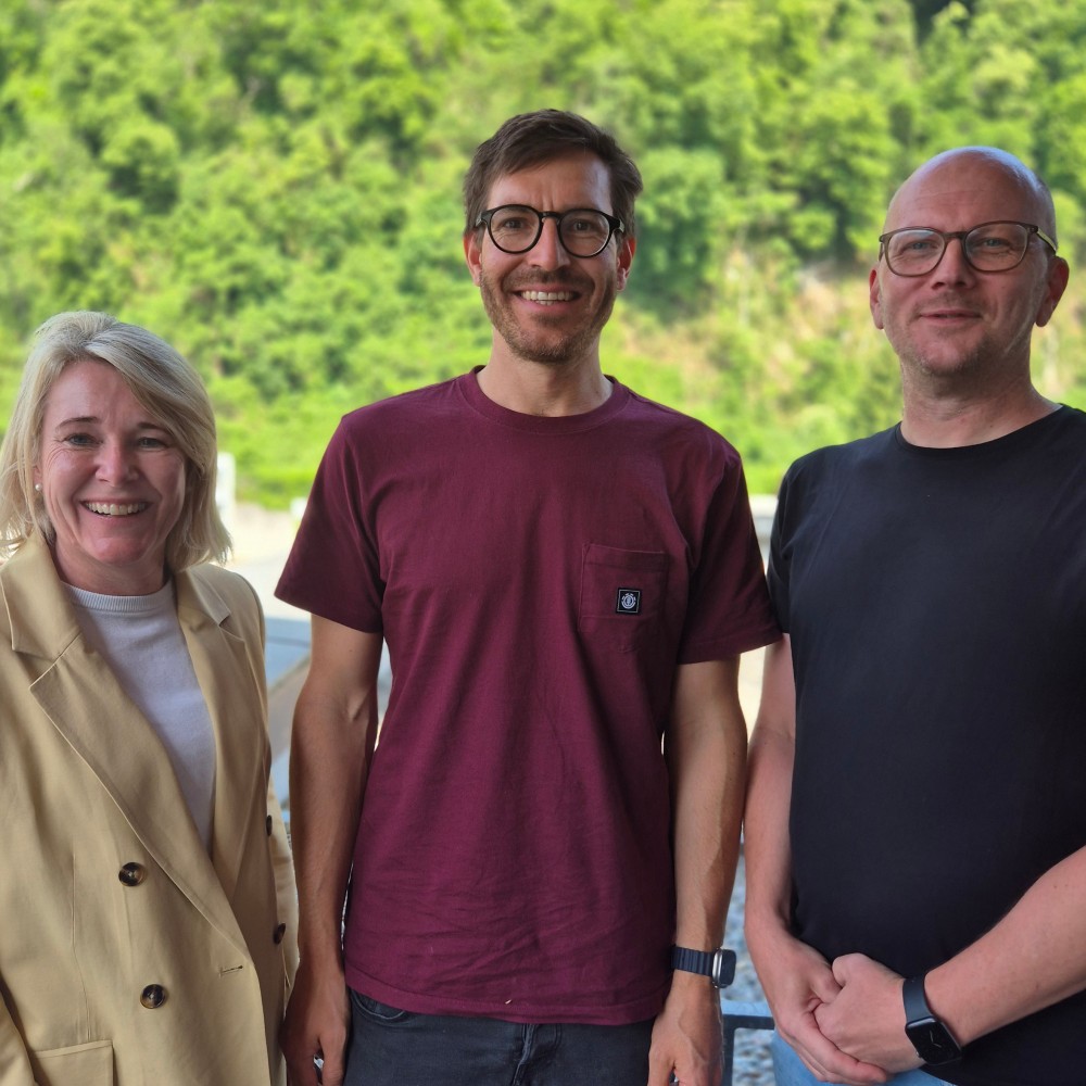 Unser neuer Betriebsarzt Christian Willomitzer (Mitte) und unsere Geschäftsführung (Yvonne Antretter-Wiedl, li, und Patrick Malang, re) lächeln in die Kamera. (c) KibeV