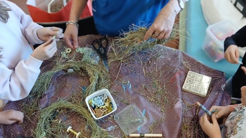 Betreuerin bastelt mit den Schulkindern in Raggal / Marul ein Osternest aus Heu. (c) KibeV