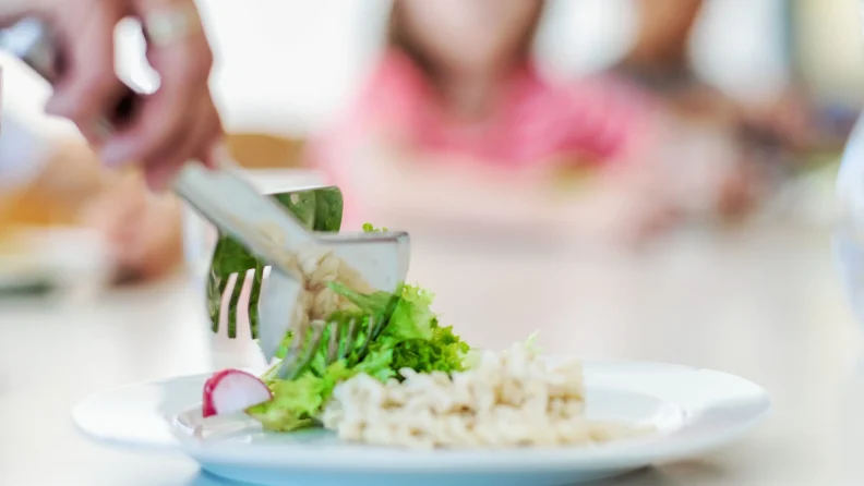 Salat wird auf einen Teller mit Risotto angerichtet. (c) KibeV