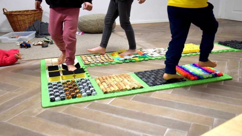 Kinderfüße gehen über einen Indoor-Barfuß-Weg im Zwergengarten Steinebach. (c) KibeV