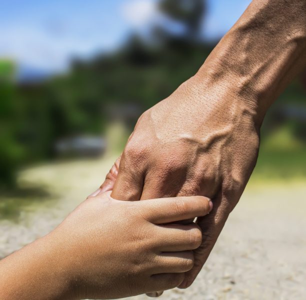 Kinderhand fasst eine Erwachsenenhand. (c) Pixabay